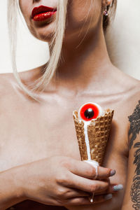 Midsection of young woman holding ice cream cone