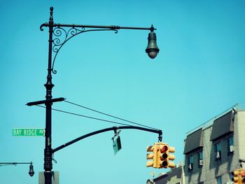 Low angle view of road signal and street light