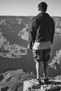 Rear view of man standing on rock