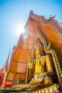 Low angle view of statue against temple building against sky