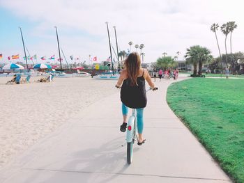 Rear view of woman on bicycle at beach