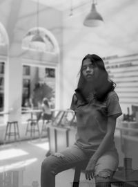 Portrait of young woman sitting in city