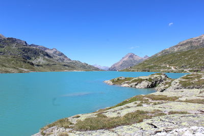 Scenic view of lago bianco in bernina pass against blue sky