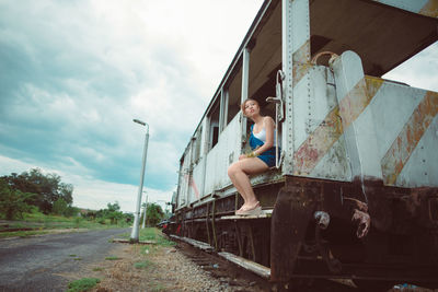 Full length of young woman sitting in miniature train