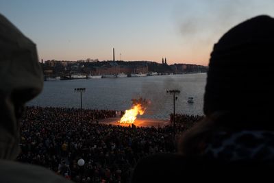 Close-up of crowd in city against sky during sunset
