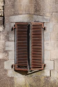 Close-up of metal grate against brick wall