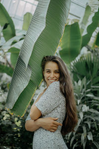 Front view of a smiling young woman amidst plants