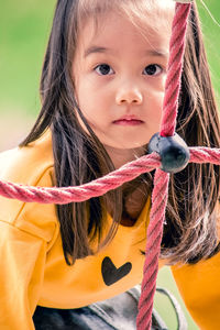 Close-up portrait of girl climbing rope