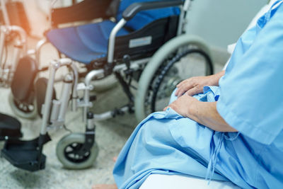 Midsection of senior female patient sitting at hospital