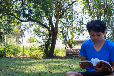 Portrait of young man sitting on land