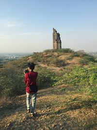 Rear view full length of man photographing on mountain