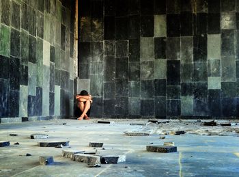 Mature man sitting in abandoned house