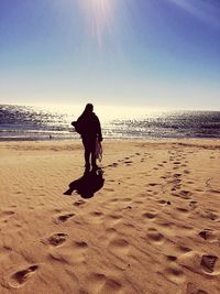 Silhouette man standing on beach against sky during sunset