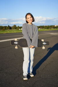 Portrait of young woman walking on road