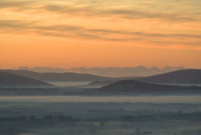 Scenic view of mountains against orange sky