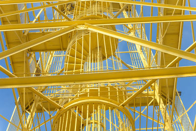 Low angle view of metallic structure against blue sky