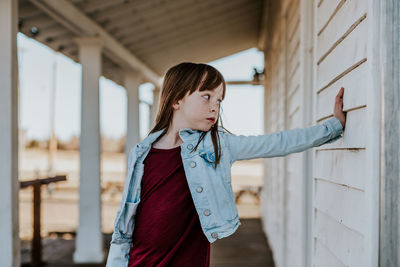 Young girl standing on patio making a silly face