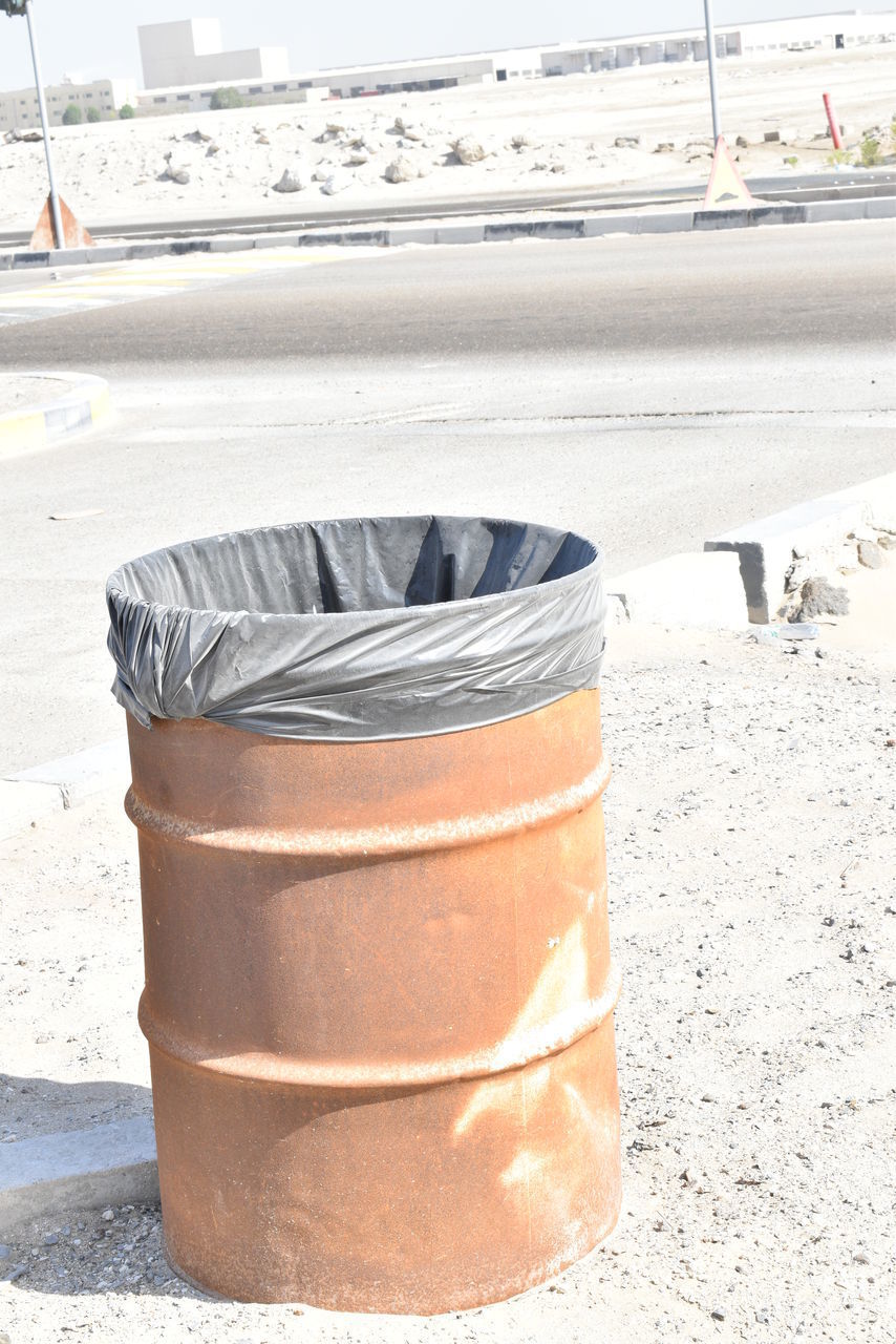 CLOSE-UP OF GARBAGE CAN ON FOOTPATH