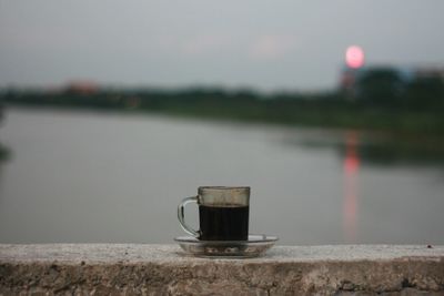 Close-up of coffee cup against sky