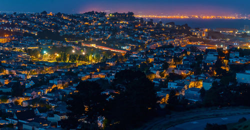 Aerial view of illuminated cityscape against sky at night