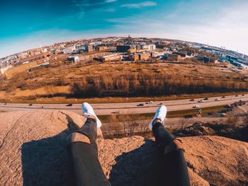 People sitting on rock against sky