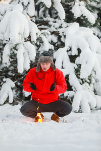 Portrait of young man skiing on snow covered field