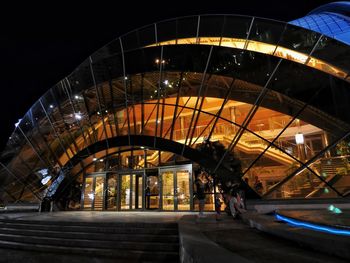 Man on illuminated bridge at night