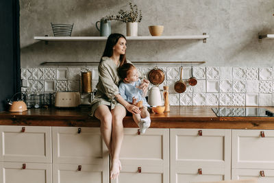 Happy mom and little daughter cooking together in the kitchen