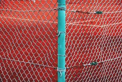 Full frame shot of metal fence against wall