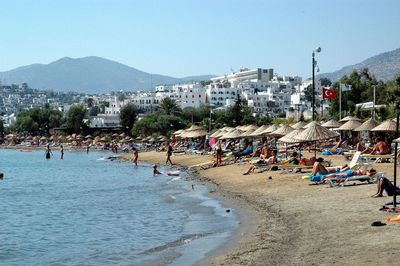 People at beach against clear sky