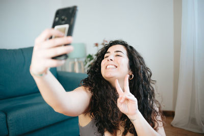 Smiling young woman talking on video call at home