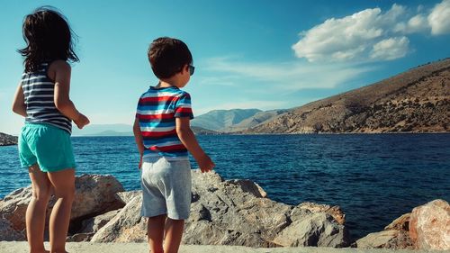 Rear view of children standing on beach