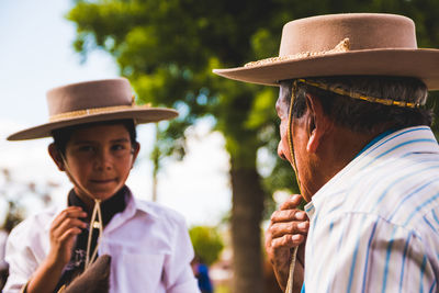Close-up of grandfather and grandson wearing cowboy hat