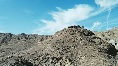 Low angle view of people on mountain against sky