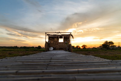 Built structure on field against sky at sunset