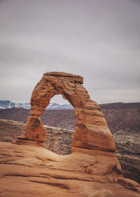 A man with a child is standing under delicate arch at arches np