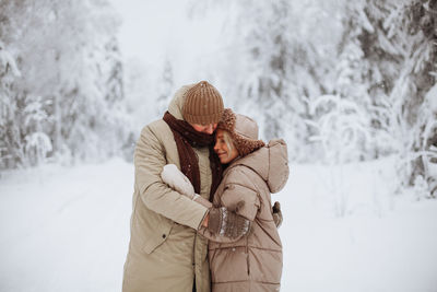 Loving couple hugging in the winter forest