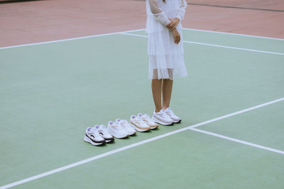 Low section of woman standing on tennis court