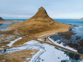 Scenic view of mountains by sea against sky