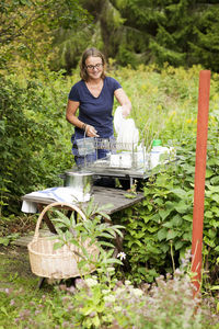 Mature woman washing dishes in garden