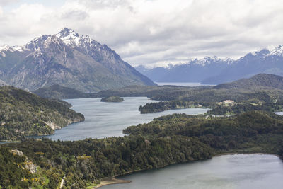 Scenic view of mountains and river against cloudy sky