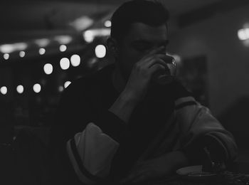 Close-up of young man drinking coffee at cafe