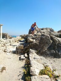 Low angle view of tourists on rock