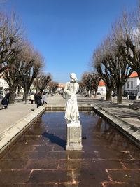 Statue by trees against sky