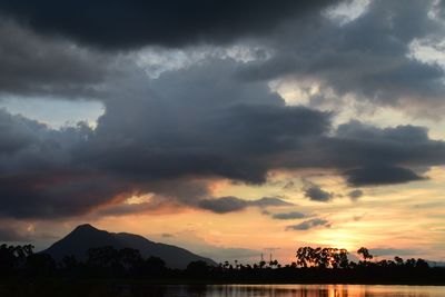 Scenic view of silhouette mountain against dramatic sky during sunset