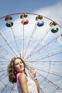 Low angle view of woman in amusement park against sky