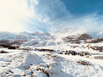 Snow covered landscape against sky