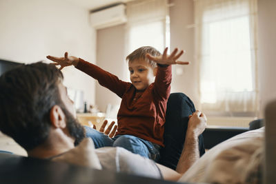 Father and little son playing together at home