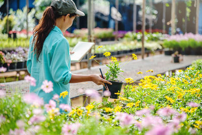 Woman working on flowering plant