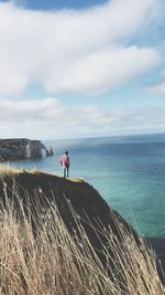 Man standing on sea shore against sky